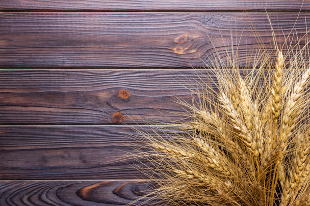 田舎の木製のテーブルの上に熟した小麦の小花のクローズアップビュー - 写真・画像