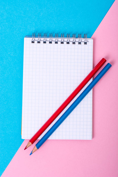 Notepad for notes and colorful pencils on colored background - Φωτογραφία, εικόνα