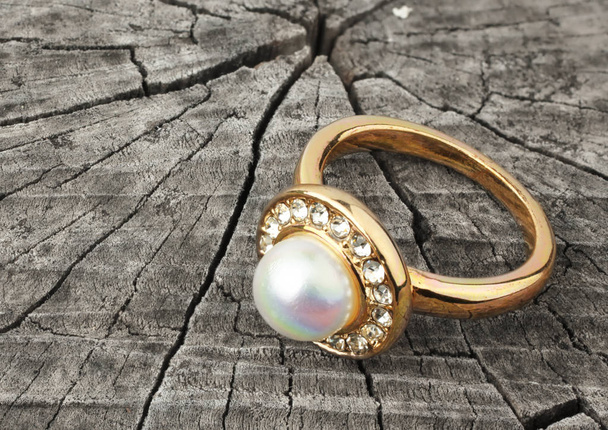 Jewellery ring with pearl on wood background - Valokuva, kuva