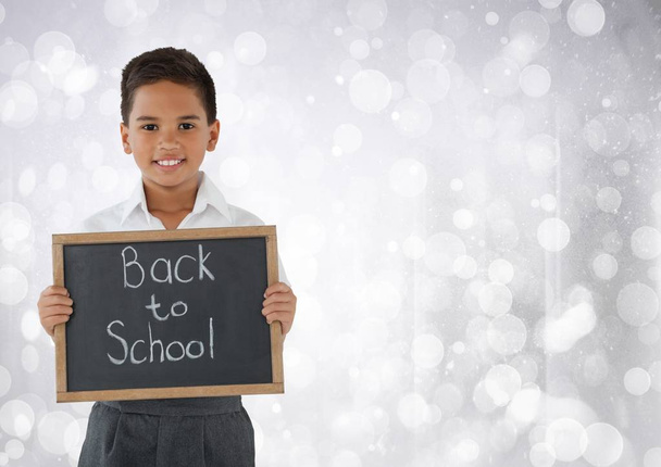 Schoolboy holding back to school blackboard - 写真・画像