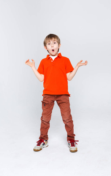 Emotional portrait of casual surprised boy at studio background - Fotó, kép