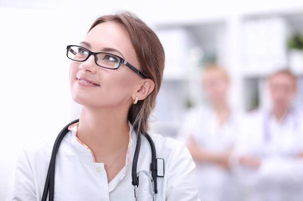 Young woman doctor standing at hospital with medical stethoscope - Foto, Imagem