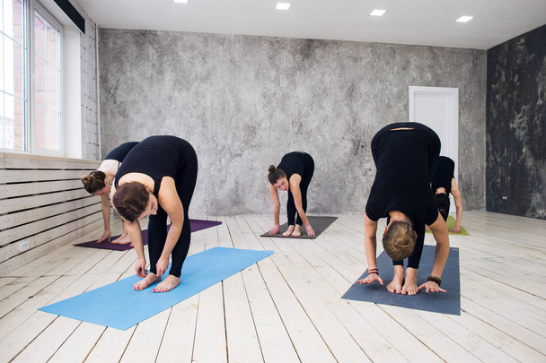 Grupa robienie yoga w siłowni. Przyjmując z zadowoleniem na zajęcia jogi. Ćwiczenia rozpoczyna się w pomieszczeniu - Zdjęcie, obraz