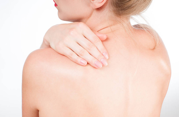Woman has neck pain. Nude shoulders girl from the back. - Foto, immagini