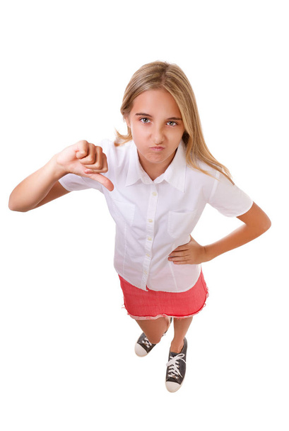 Leuk hoge hoek hoofdgedeelte portret van tienermeisje toont duim omlaag gebaar, geïsoleerd - Foto, afbeelding