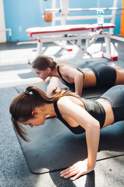 Two woman friends or sportsmen exercising in gym - Фото, зображення