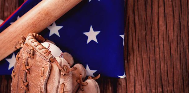 Baseball bat and gloves on American flag - Фото, зображення