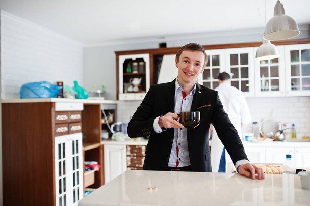 Portrait of a handsome groom drinking coffee in the kitchen. - Valokuva, kuva