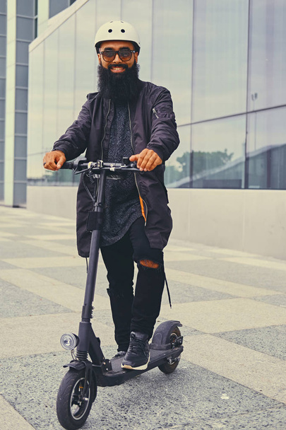 A man posing on electric scooter. - Фото, изображение