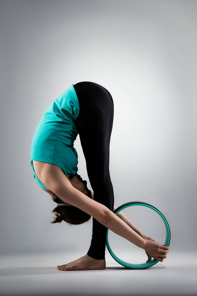 hermosa mujer de yoga de pie en fondo gris
 - Foto, imagen