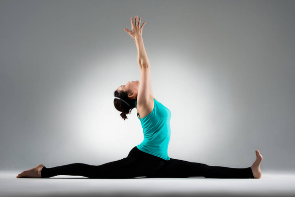 yoga student split her legs and hands up - Foto, Bild
