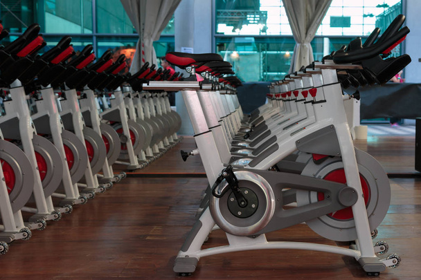 Fitness Workout in Gym : Groupe de vélos de spinning modernes en ligne
 - Photo, image