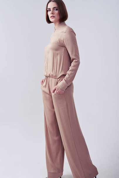 Bej rengi tulum giymiş poz yakışıklı süper model - Fotoğraf, Görsel
