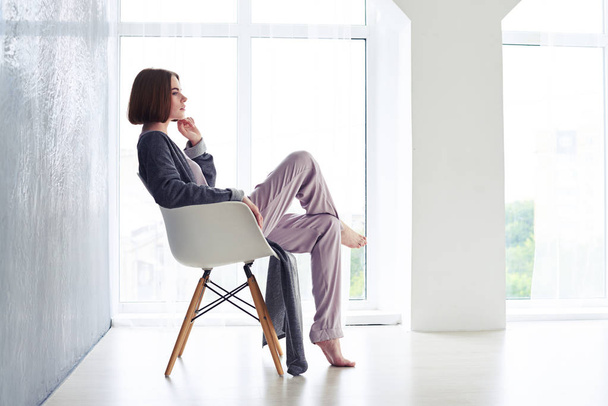 Восхитительная женщина наслаждается отдыхом и сидит на кресле
 - Фото, изображение