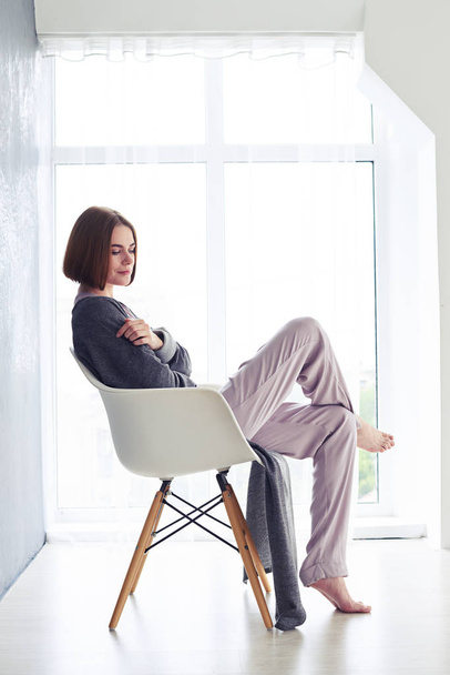 Tunteellinen nainen nauttii lepoa ja istuu nojatuolissa
 - Valokuva, kuva