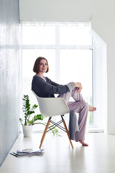 hübsche Kastanie im Pyjama genießt Ruhe auf Sessel - Foto, Bild