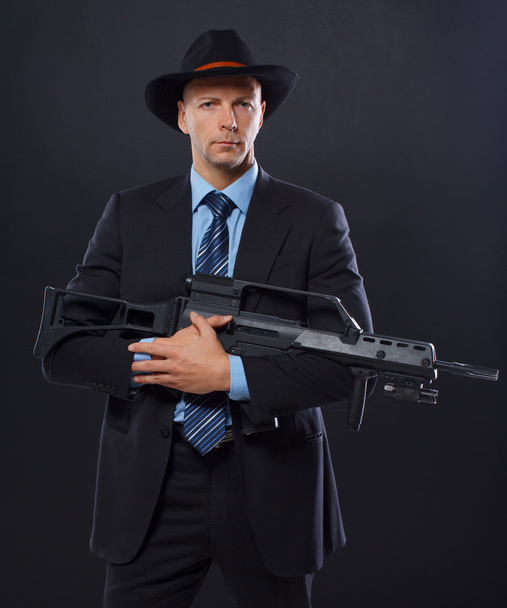 man is posing on the floor with a gun - Foto, Bild