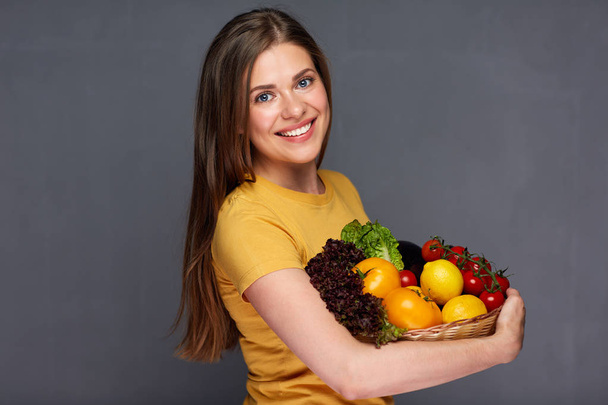 Smiling woman holding vegan food ingredients.  - Fotó, kép