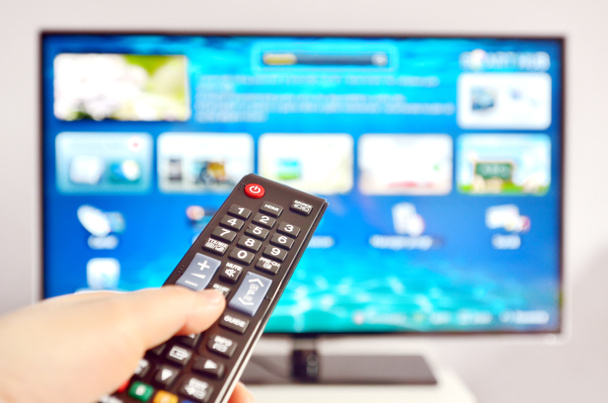 Smart tv and hand pressing remote control - Photo, Image