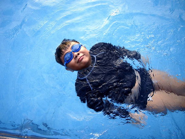 Młody chłopak, pływanie i pływające w basenie - Zdjęcie, obraz
