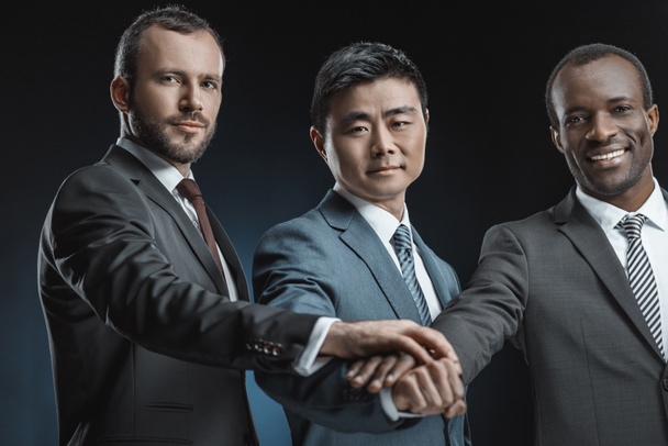 hombres de negocios multiétnicos tomados de la mano
 - Foto, imagen