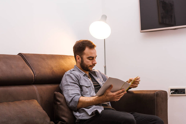 Businessman reading magazine at home - Фото, зображення