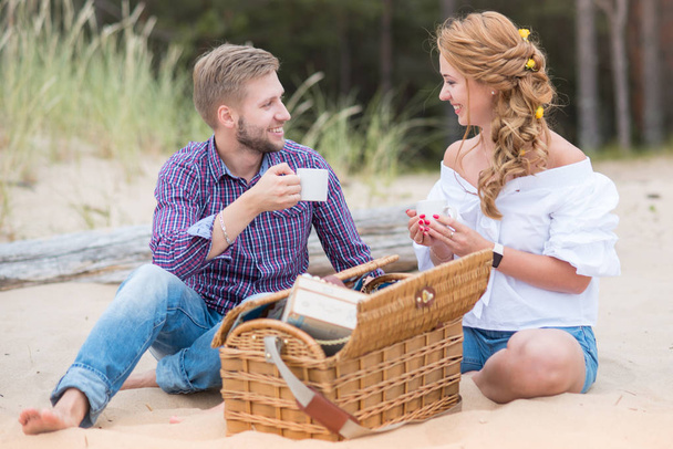Nuori perhe pari ottaa piknik rannalla lähellä merta, dri
 - Valokuva, kuva