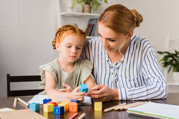 mother and daughter learning with letter cubes - Zdjęcie, obraz