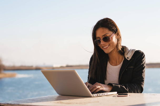Girl in sunglasses working with laptop  - Фото, изображение