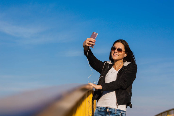 Girl making selfie on bridge   - Valokuva, kuva