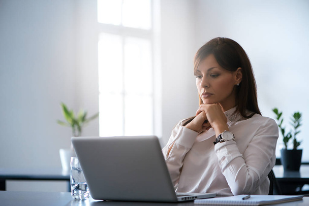Woman in office working with laptop - Photo, Image