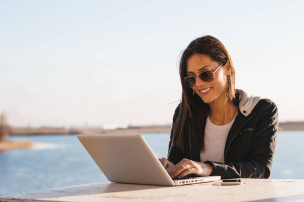 Girl in sunglasses working with laptop  - Fotoğraf, Görsel