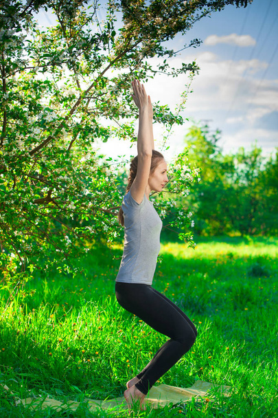 mooie vrouw doet yoga buiten op gras - Foto, afbeelding