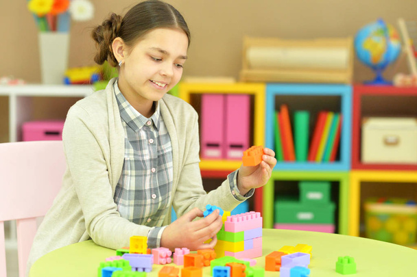 teenage girl playing with plastic blocks  - Fotó, kép