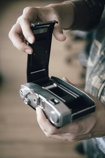 Vintage photo camera in the hands of man, soft focus. - Fotó, kép