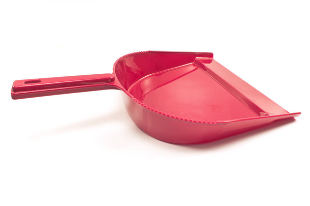 Червоний пластиковий пилозбірник для очищення ізольований на білому
 - Фото, зображення