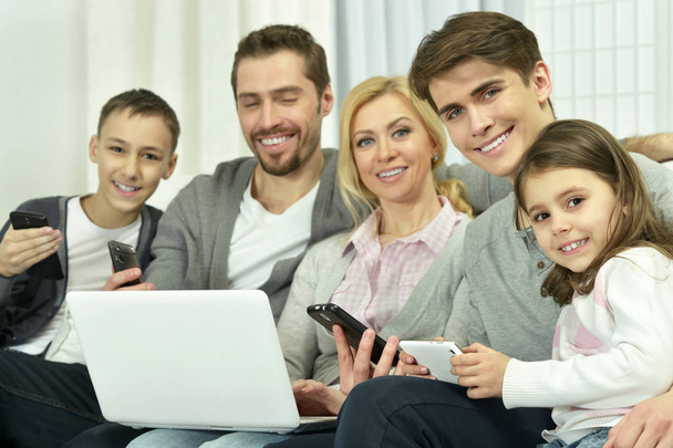 Rodzina siedzi na kanapie z laptopem  - Zdjęcie, obraz