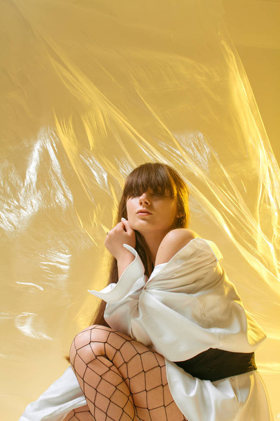 Stylowa dziewczyna w modne ubrania na tle folii przezroczystych - Zdjęcie, obraz