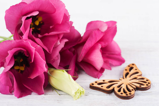 розовые фиолетовые цветы и деревянная бабочка
 - Фото, изображение