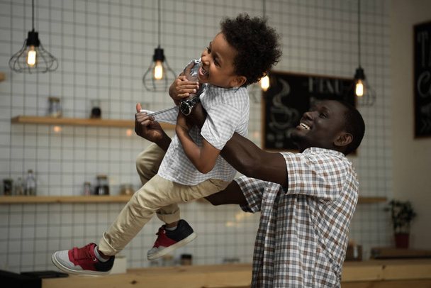 Afrikanisch-amerikanischer Vater trägt Sohn - Foto, Bild