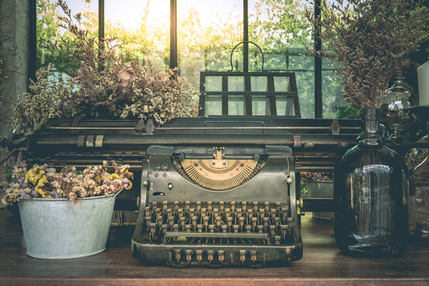 Antigua máquina de escribir adornos vintage y jarrones de flores secas
  - Foto, imagen