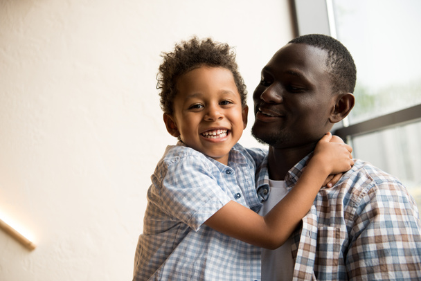 african american father and child hugging - Фото, зображення