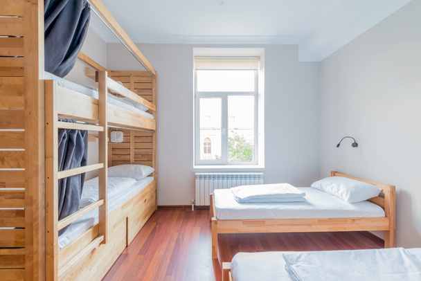 Hostel κοιτώνες κρεβάτια που διοργανώνονται στο δωμάτιο - Φωτογραφία, εικόνα