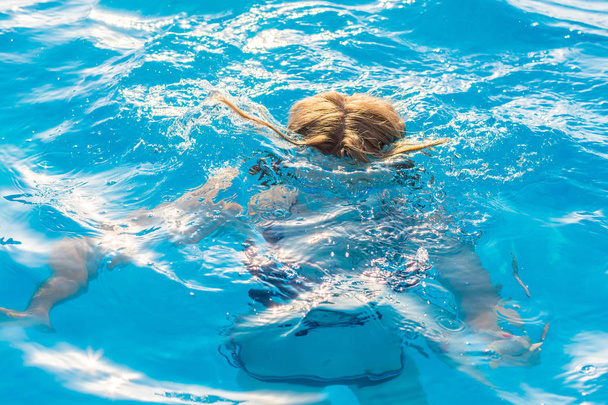 Girl dives in the pool with glasses for swimming - Foto, Imagem