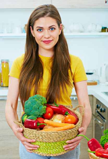 woman holding wicker basket with vegetables - Фото, зображення