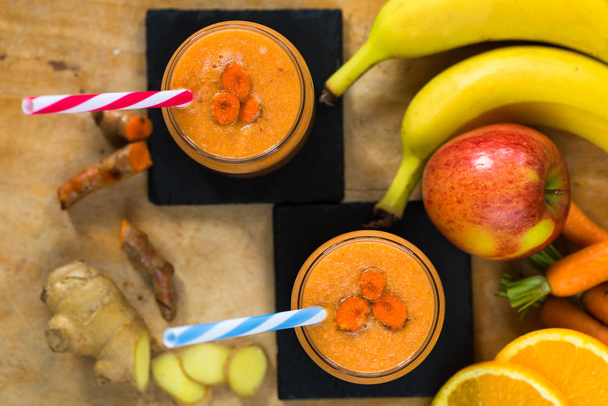 Smoothie with carrot, apple, orange, banana, ginger and tumeric - Fotoğraf, Görsel