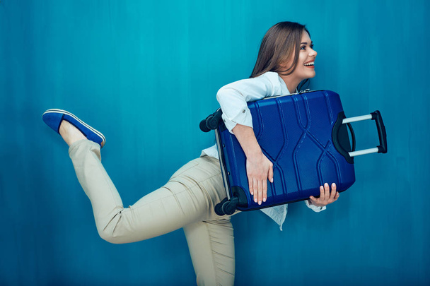 young woman holding blue suitcase  - Fotó, kép