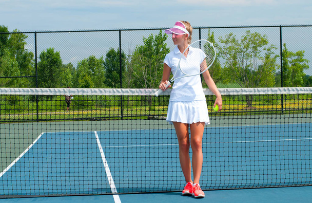 Young woman is playing tennis on the tennis court - Photo, Image