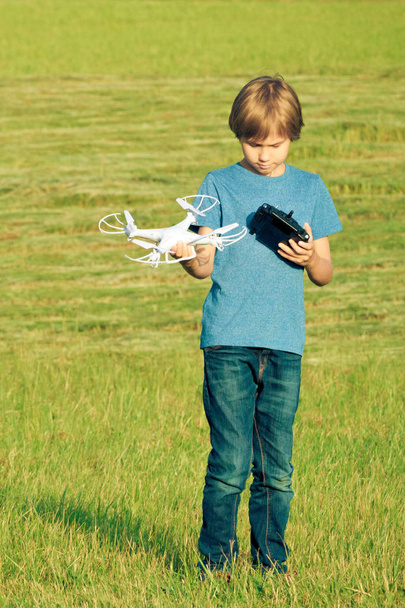Αγόρι παίζει με drone σε εξωτερικούς χώρους. - Φωτογραφία, εικόνα