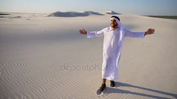 Vrolijke moslim Arabische Uae Sheikh man loopt door de uitgestrekte woestijn met glimlach op gezicht op duidelijke zomerdag. - Video